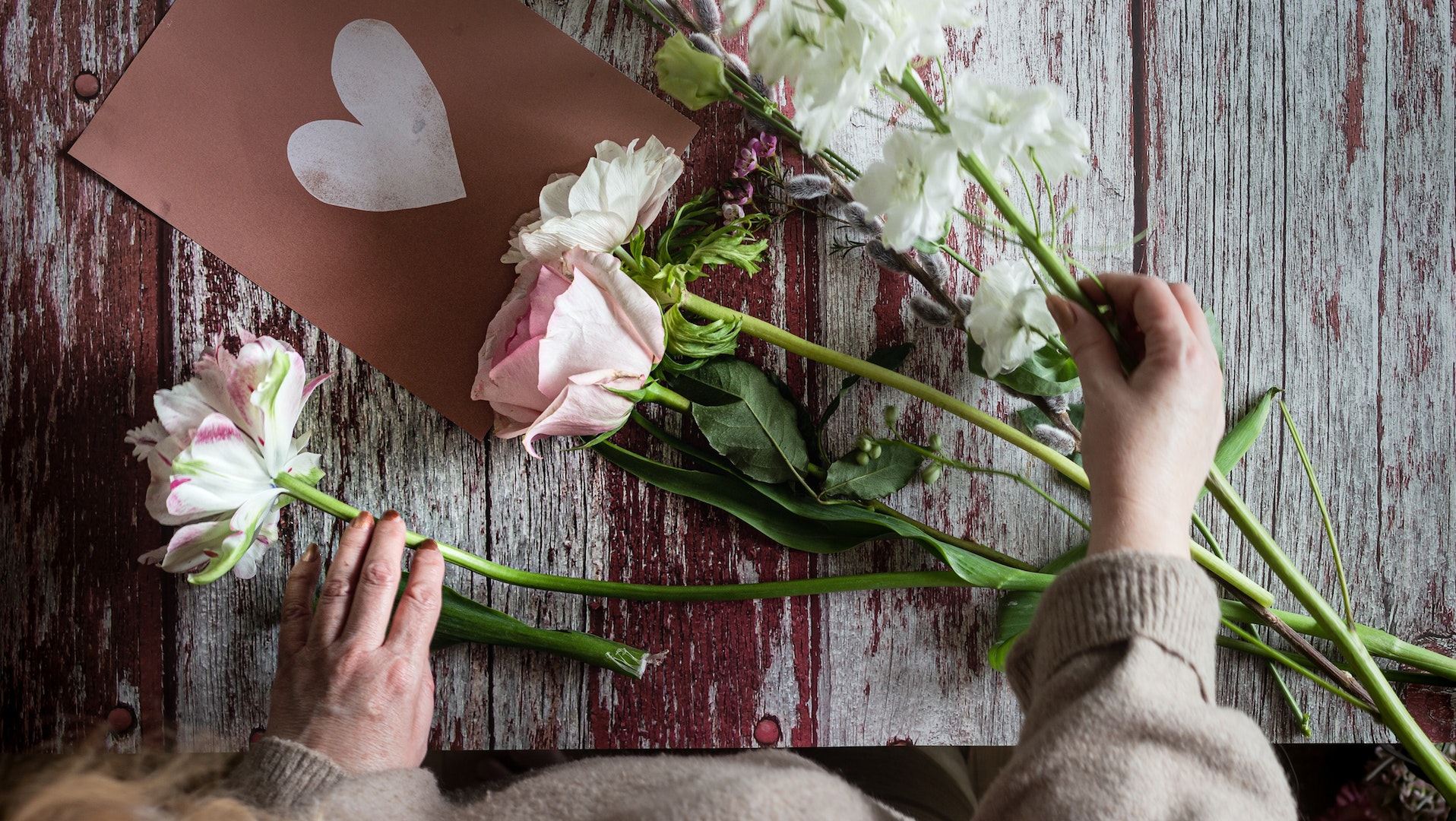 A photo of a person putting together a floral arrangement for Palentine's Day