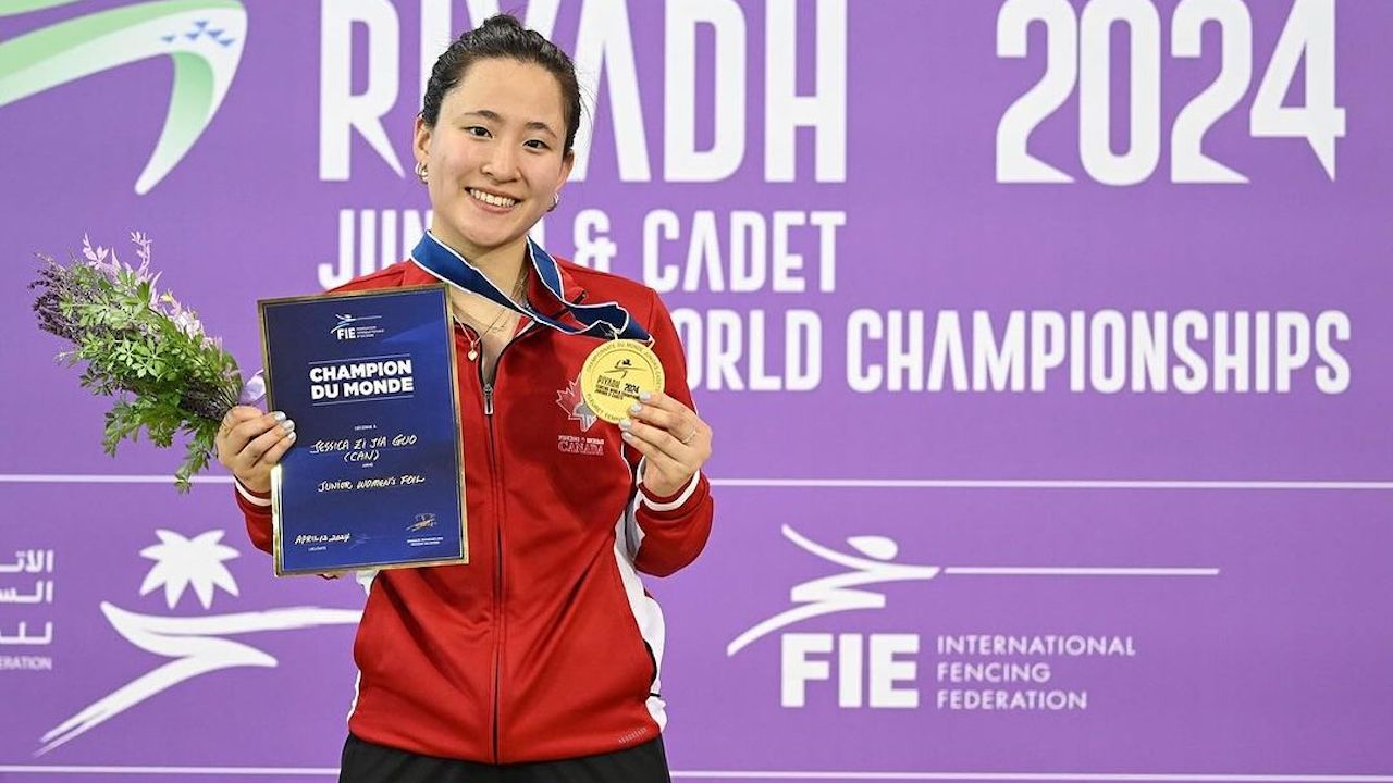 Fencer Jessica Guo stands holding a gold medal at the 2024 FIE Junior World Championships