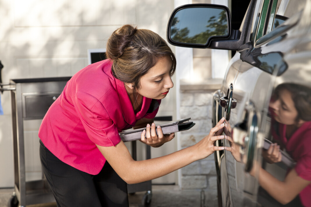 Automobile insurance adjuster inspecting damage to vehicle