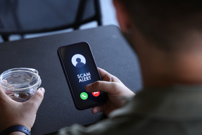 Scam alert on mobile phone screen