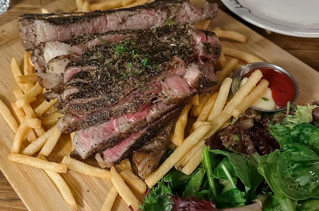 Candlelit date night steak frites with signature house sauce and unlimited thin-cut fries at Jules Bistro Toronto.